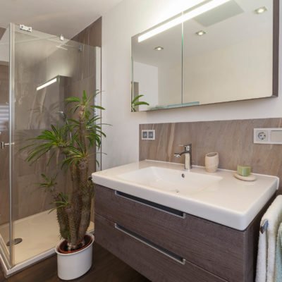 Bad-Referenzbad-marmor-und-holz-bodengleiche-Dusche-beleuchteter-Spiegelschrank-Armatur